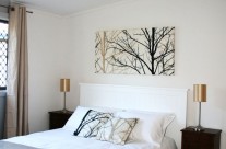 The master bedroom has a queen sized bed and is cosy and bright, tastefully decorated in natural tones.